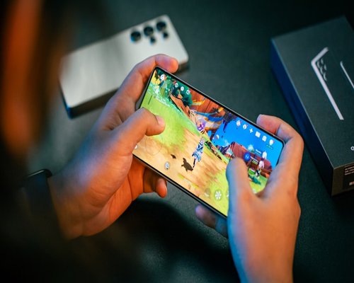 Smartphone with a fictional beginner-friendly game screen displayed during a gaming exhibition